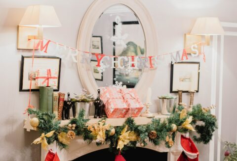 Merry Christmas letter banner hanging on sconces in white painted room